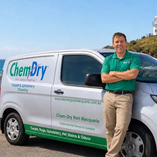 The Chem-Dry Port Macquarie operator in a green Chem-Dry polo, smiling beside the Chem-Dry Port Macquarie van
